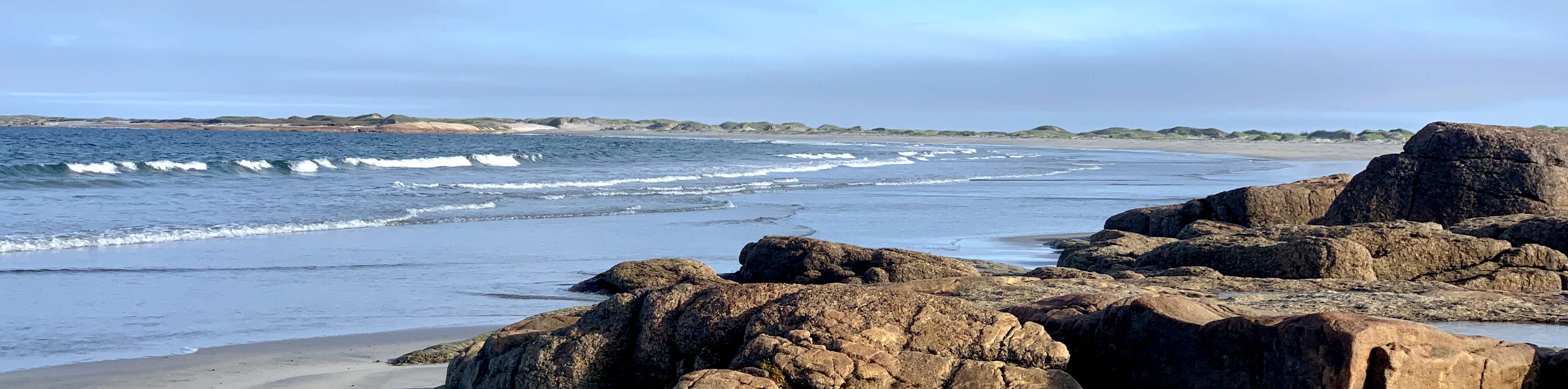 A landscape of waves crashing on the rocky beach of Georgian Bay, Ontario, on a sunny day
